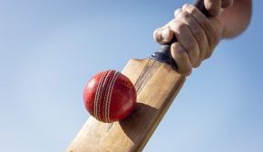 Cricket player batsman hitting a ball with a bat shot from below background